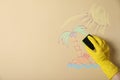 Woman erasing child`s drawing from beige wall, closeup Royalty Free Stock Photo