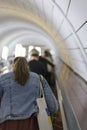 Woman on escalator view from the back. vertical photo Royalty Free Stock Photo