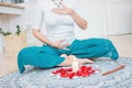 Woman in ethnic costume practicing yoga in front of candles and red rose petals, hands with mehendi on the heart chakra Royalty Free Stock Photo