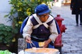 Woman of an ethnic minority in Yunnan in her traditional costume selling tofu cheese at a village market near Lijiang, Yunnan, Chi