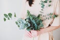 Woman with eucalyptus branches in her hands. Florist with handmade wedding bouquet