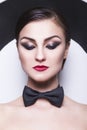 woman with evening make up and red lips in a bow-tie in a center of a dartboard background Royalty Free Stock Photo