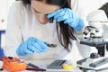 Woman examine part of digital device with magnifying glass Royalty Free Stock Photo