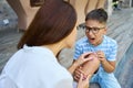 Woman examines a wound on her sons knee