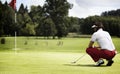 Woman examining green before putting.