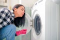 Woman is checking her broken dishwasher to explain problem to the warranty service for assistance Royalty Free Stock Photo