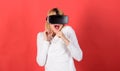 Woman excited using 3d goggles. Portrait of an amazed girl using a virtual reality headset isolated on red background Royalty Free Stock Photo