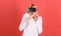 Woman excited using 3d goggles. Portrait of an amazed girl using a virtual reality headset isolated on red background Royalty Free Stock Photo
