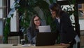 Woman executive in glasses analyzes papers brought by colleague discussing strategy of document