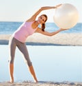 Woman, exercise ball and stretch for pilates on beach for fitness, health or wellness in portrait. Female instructor Royalty Free Stock Photo