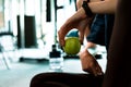 Woman exercise in gym fitness breaking and relax. hand holding apple fruit after training sport and dumbbell, water bottle on the