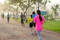 Woman exercise jogging in park with blurred people in background.