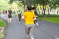 Woman exercise jogging in park with blurred people in background.
