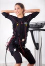 Woman exercise trunk-bending forward on electro stimulation ma Royalty Free Stock Photo