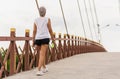 Woman exercise walking on the bridge with bottle water in her hand. Royalty Free Stock Photo