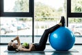 Woman exercising with blue fitness ball on fitness mat