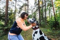 Woman exercising with Dalmatian dog in forest Royalty Free Stock Photo