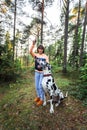 Woman exercising with Dalmatian dog in forest Royalty Free Stock Photo