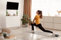 Woman Exercising Doing Standing Lunge Stretch Watching TV At Home Royalty Free Stock Photo