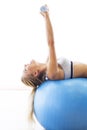 Woman exercising with dumbbells on a fitness ball Royalty Free Stock Photo