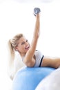 Woman exercising with dumbbells on a fitness ball Royalty Free Stock Photo