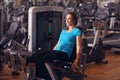 Woman exercising in gym with exercise-machine - leg day, wellbeing concept. Royalty Free Stock Photo