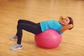 Woman exercising her abs on a pink Pilates ball indoors. Royalty Free Stock Photo