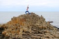 Woman exercising on rocks at Giants Causeway