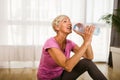 Woman exercising and stretching her body doing flexibility exercises, she drink water after exercise Royalty Free Stock Photo