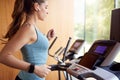 Woman Exercising On Treadmill At Home Wearing Wireless Earphones Checking Smart Watch