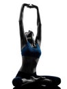 Woman exercising yoga meditating sitting stretching silhouette Royalty Free Stock Photo
