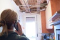 Woman explaining a kitchen ceiling incident to her homeowner`s insurance company