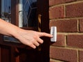Woman extends her hand to ring doorbell Royalty Free Stock Photo
