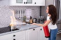 Woman Extinguishing Burning Cooking Pot Royalty Free Stock Photo