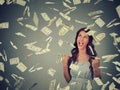 Woman exults pumping fists ecstatic celebrates success under money rain falling down dollar bills banknotes Royalty Free Stock Photo