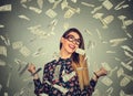 Woman exults pumping fists ecstatic celebrates success under money rain falling down dollar bills banknotes Royalty Free Stock Photo