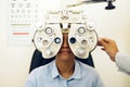 Woman, eye exam and phoropter with optometrist hand, check and lens for vision, wellness and health in clinic. Doctor Royalty Free Stock Photo