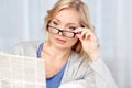 Woman in eyeglasses reading newspaper at home Royalty Free Stock Photo