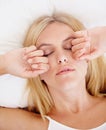 Woman, eyes closed and hands for waking up in bedroom for sleepy, tiredness or fatigue in morning. Person, burnout or