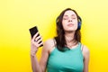 Woman with eyes closed and a smartphone in hand listening to mus Royalty Free Stock Photo