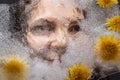 Woman eyes  through transparent ice with dandelions flowers Royalty Free Stock Photo