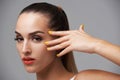 Woman face, beauty and hand with manicure, makeup and yellow nail polish, skin and cosmetics on grey background. Orange Royalty Free Stock Photo