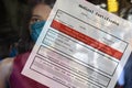 Woman face with blank personal medical certificate form free from colonavirus disease or COVID-19