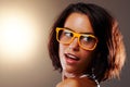Woman, face and closeup with glasses in studio for vision, sight and trendy fashion mock up on brown background. Female