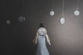 woman with face hidden by a clock in a room full of grandfather clocks