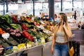 Woman with face mask buying fruit and vegetables at the central city market Royalty Free Stock Photo