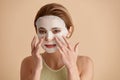 Woman Face Mask. Portrait Of Beautiful Girl Applying Cosmetic White Textile Mask Royalty Free Stock Photo