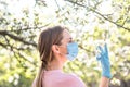 Woman with face mask on quarantine. Stay at home. Family concept. young woman blowing dandelion. glass of champagne on the beach.