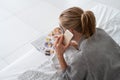 Woman with face mask relaxing lying on the bed reading a magazine ordering food