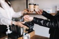 Woman with face mask serving in coffee shop open after lockdown. Woman pay using smarphone and nfc technology. Closeup Royalty Free Stock Photo